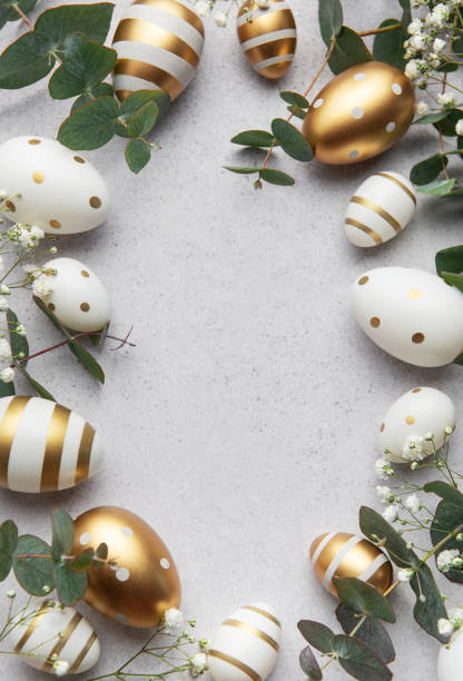 istock Easter eggs with gold and white decorations forming a frame on a gray background 2199295086
