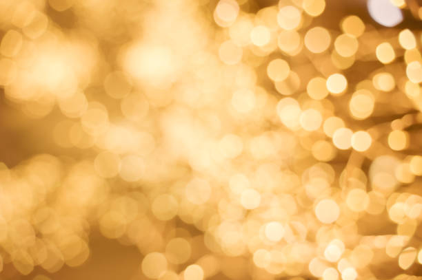 beautifully decorated Christmas tree adorned with colorful baubles and sparkling lights. The soft golden bokeh in the background enhances the holiday charm, creating a warm, festive ambiance.