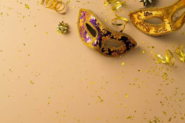 istock Carnival masks with glittering tinsel on beige background. Venice carnival, Mardi Gras, masquerade concept. 2199303217