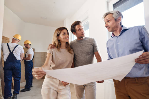 istock Happy couple working on plans with an architect during home renovation process. 2199304564