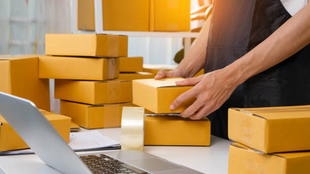 istock Small business owner packing boxes for online orders ready for shipping, Man taping cardboard boxes for shipping, Preparing to send packages, preparing/packing boxes of online orders 2199305559