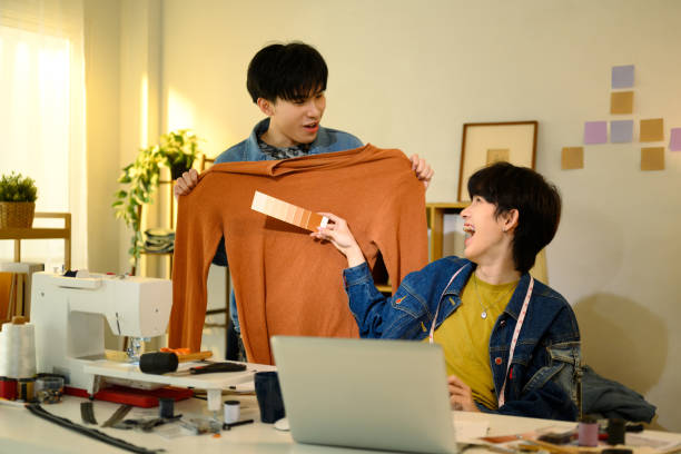 istock Two young fashion designers comparing fabric colors in a creative studio 2199307611