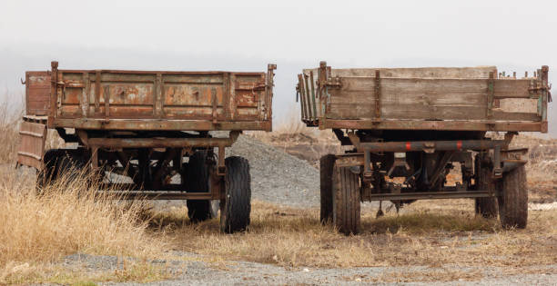 istock Two old wooden trucks are parked in a field 2199307752