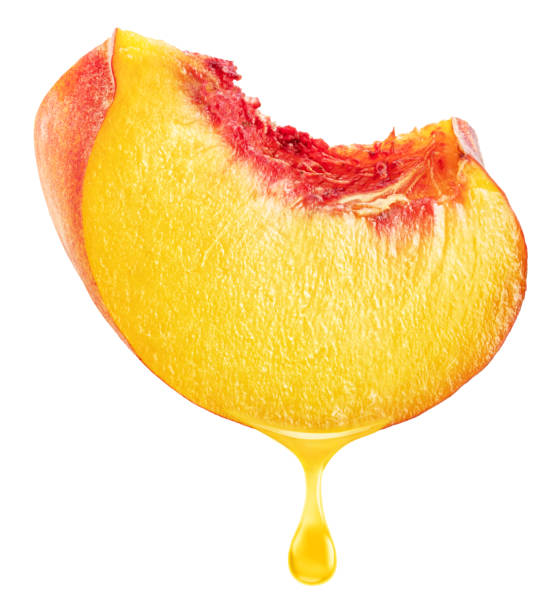 istock Slice of peach fruit and peach juice dripping from it on a white background. File includes clipping path. 2199310642