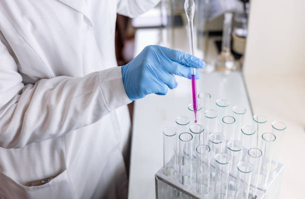 istock Scientist dripping color liquid into test tube in laboratory. Pipette with a drop and scientific laboratory test tubes in a research laboratory. Medical science laboratory glassware. 2199312770