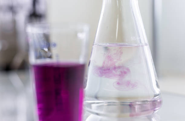 istock Chemistry laboratory glassware with color liquids. Laboratory analysis. Glassware with different liquids on white table indoors, closeup. 2199313407