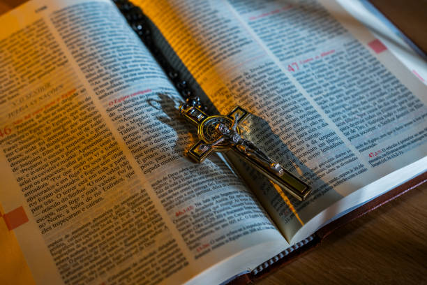 An open Portuguese Bible with a rosary and crucifix cross resting on its pages, symbolizing faith, devotion, and Christian spirituality.