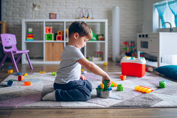 Little happy boy playing with educational toys in his room