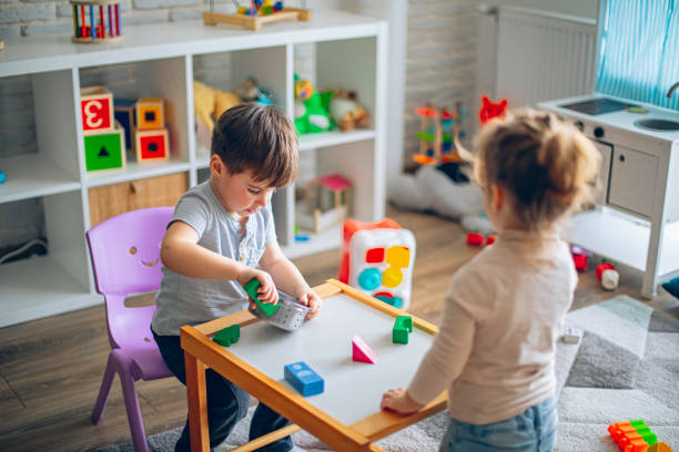 istock Little kids playing with toys in their room, making lunch from toys 2199317841