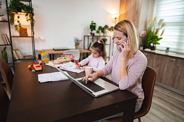 istock Busy mother working from home and having a phone call while her daughter is drawing 2199319640