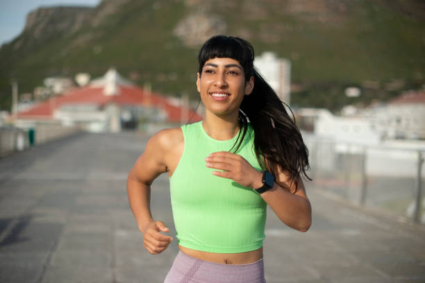 istock Running, exercise and morning with woman at beach for marathon practice, cardio workout and wellness. Fitness challenge, energy and sports athlete with person training on promenade for runner 2199320573