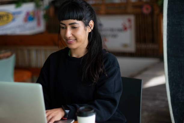 istock Coffee, laptop remote work with woman in cafe for administration, planning or reporting. Computer, smile and typing with happy freelance employee in restaurant for email or internet research 2199320600