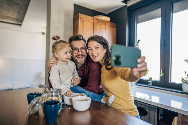 istock Happy family taking a selfie in modern kitchen 2199322176
