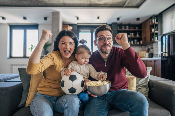 istock Family celebrating soccer game at home 2199322490
