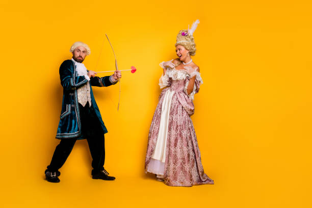istock A Costumed Couple in Historical Attire Posing on a Yellow Background 2199323211