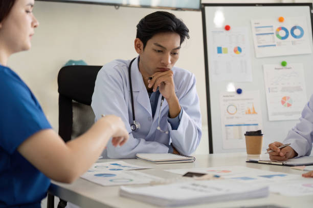 istock Medical professionals engaged in a collaborative meeting analyzing healthcare data and strategies. 2199324875