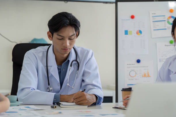 istock Doctor taking notes during a healthcare strategy meeting with colleagues. 2199324954