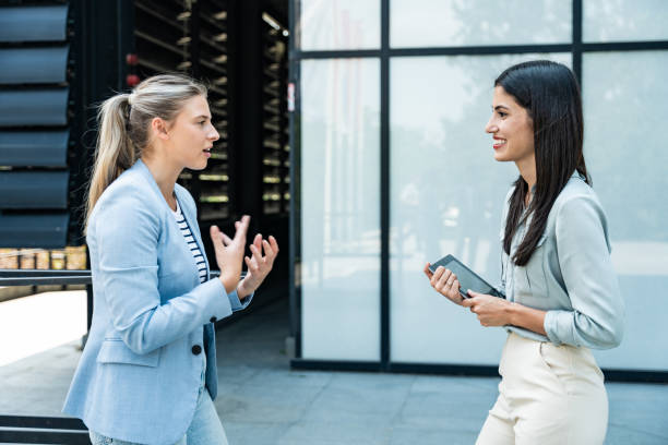 istock Professional occupation, office workers. Two business people meet before staff meeting and presentation in office building, to talk and discus plans and tactic of speech theme. Finance and economy. 2199327043