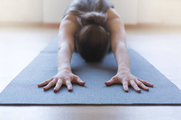 Rear view photo of woman practices seated yoga pose, focusing on deep stretching and promoting mindfulness against white studio background. Concept of beauty, mental health, concentration. Ad
