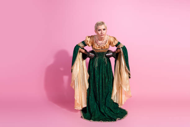 A woman dressed in a luxurious historical costume stands proudly, accessorized with knight's gauntlets and set against a pastel pink background. A mix of vintage elegance and contemporary creativity.