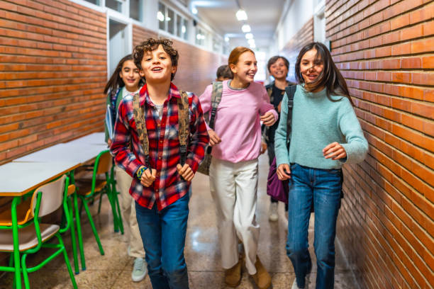istock Group of students running in school hallway 2199328223
