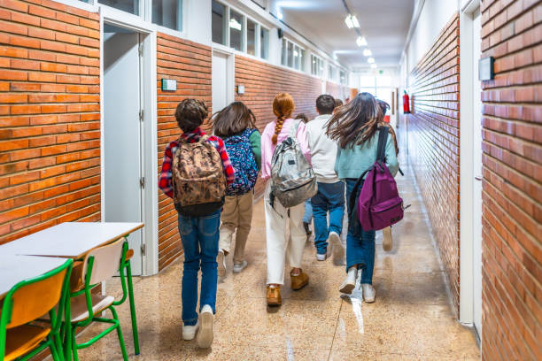 istock Group of students running in school hallway 2199328227
