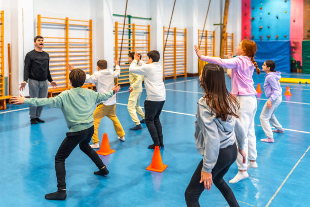 Group of elementary age students doing gymnastics exercises in school gym
