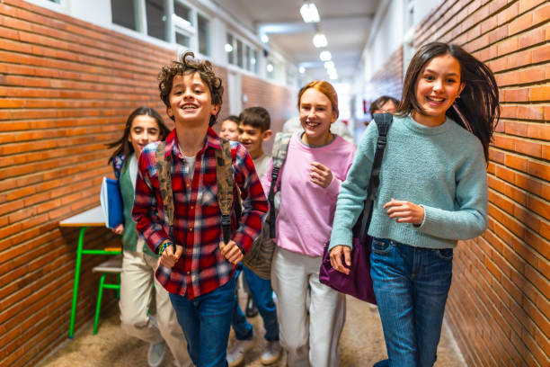 istock Group of elementary school students running in school hallway 2199328233