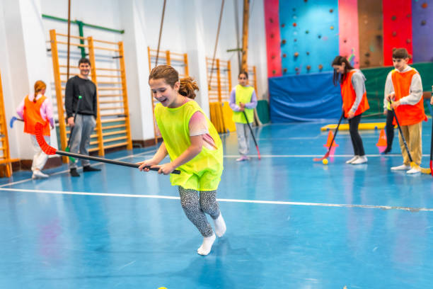 istock Girl running with floorball stick during school gym class 2199328265