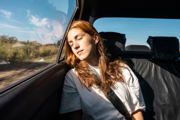 Young woman sleeping at car