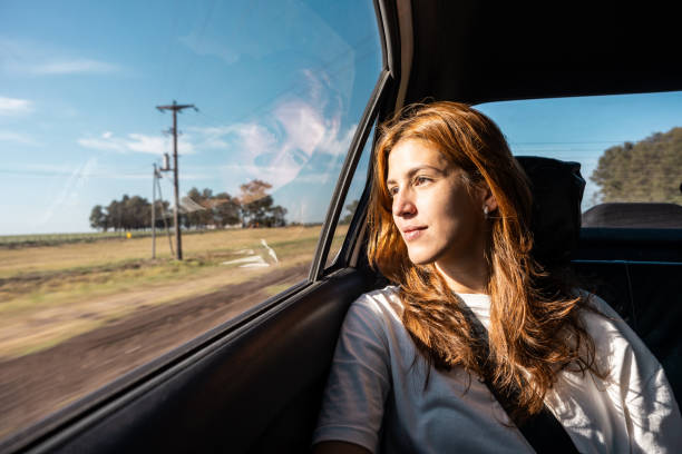 istock Young woman looking outside at car 2199330330