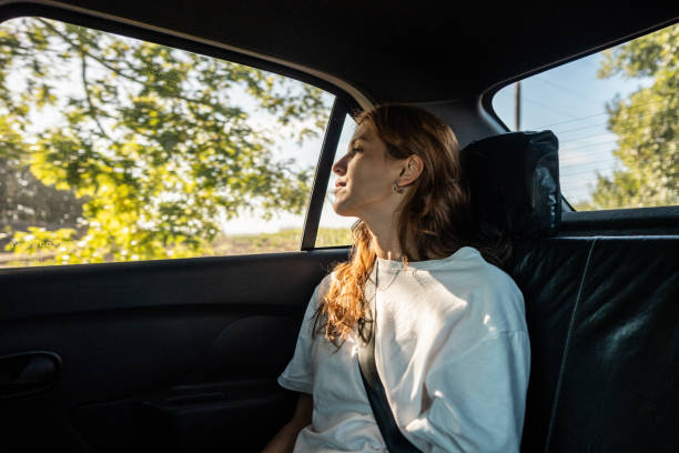 istock Young woman looking outside at car 2199330351