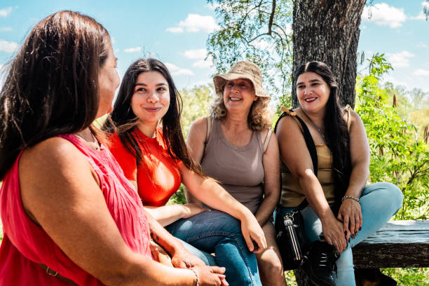istock Female friends talking at public park 2199330697