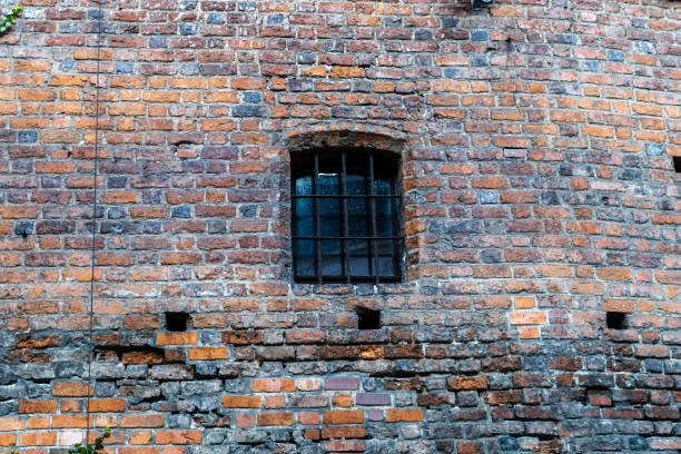 Barred window against an old red brick wall. Wroclaw, Poland