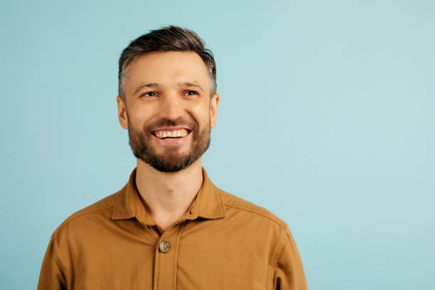 istock Pensive middle aged man thinking, looking aside at free space, posing on blue studio background. Let me think concept 2199338179