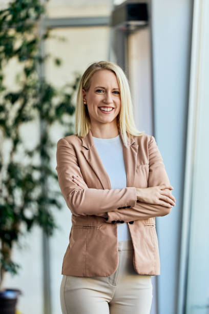 istock Confident Professional Woman Standing in Modern Office Environment Smiling at Camera 2199340110