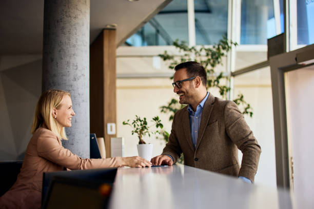 istock Two Professionals Discussing at a Reception Desk in a Modern Business Office 2199340155