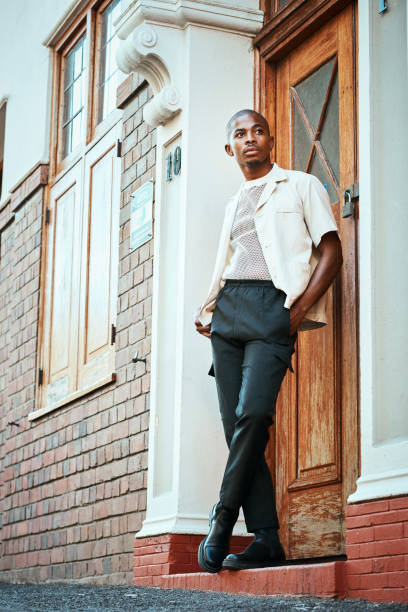 istock Stylish Man Posing Confidently Next to a Vintage Door in Urban Setting 2199341673