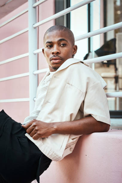 istock Stylish Individual Leaning Against a Pink Wall in Urban Environment 2199341697
