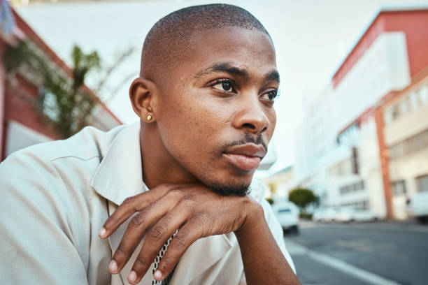 Young Man Resting His Chin on His Hand in an Urban Setting