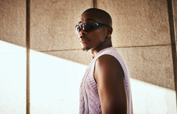 istock Confident Man in Stylish Sunglasses and Sweater Standing in Dramatic Lighting 2199341732