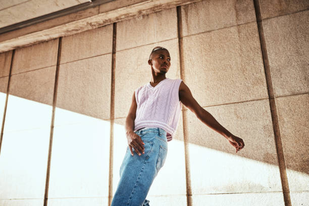 istock Stylish Individual Posing in Casual Attire Under Modern Architectural Setting 2199341740