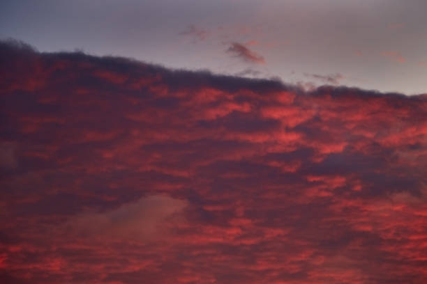 The burning sun paints the clouds in crimson hues.