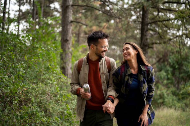 istock Young couple having fun while walking and hiking throughout forrest 2199342931