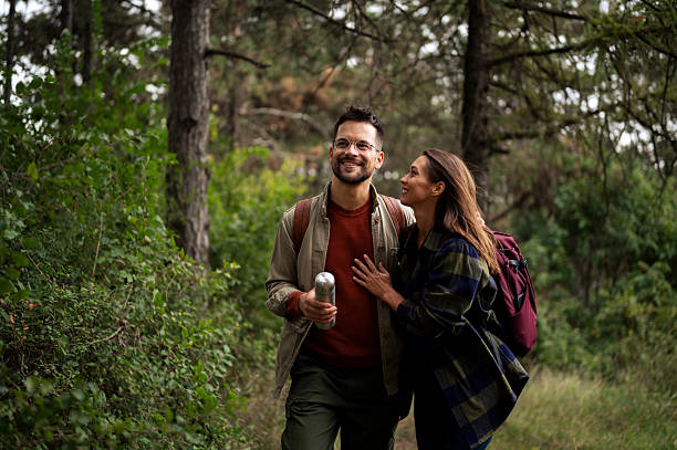 istock Young couple having fun while walking and hiking throughout forrest 2199342933