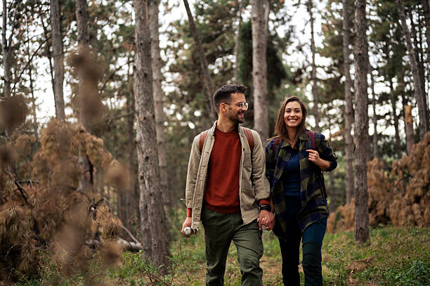 istock Young couple having fun while walking and hiking throughout forrest 2199342974
