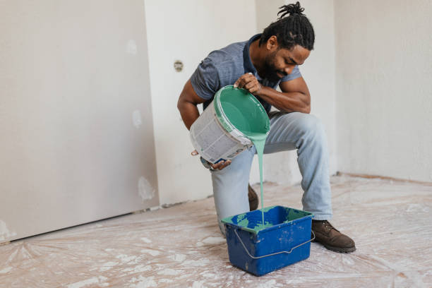 istock Man Pouring Paint into Tray for Artistic Project 2199344262