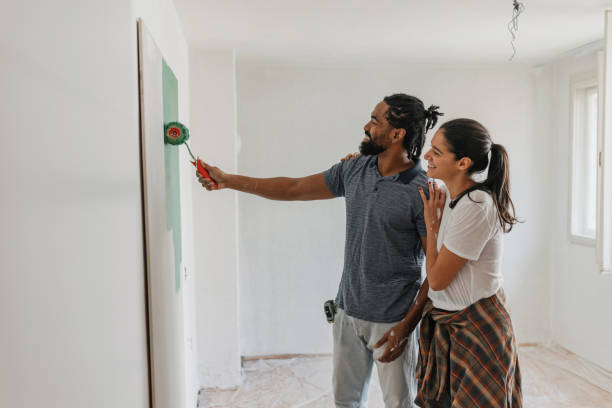 istock Couple Laughing While Painting Their Home Together 2199344302
