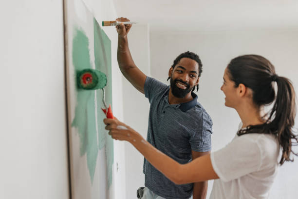 istock Happy Couple Painting Together with Smiles 2199344414
