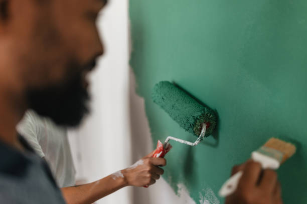 istock Focused Couple Painting Wall - Collaboration in Action 2199344620